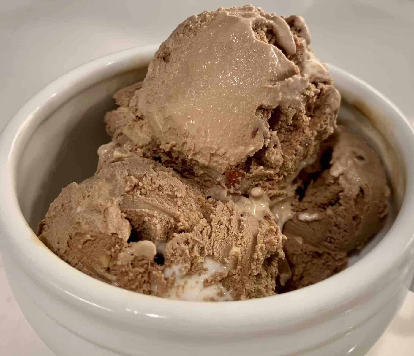 white bowl with three scoops of haagen-dazs rocky road ice cream on a white counter