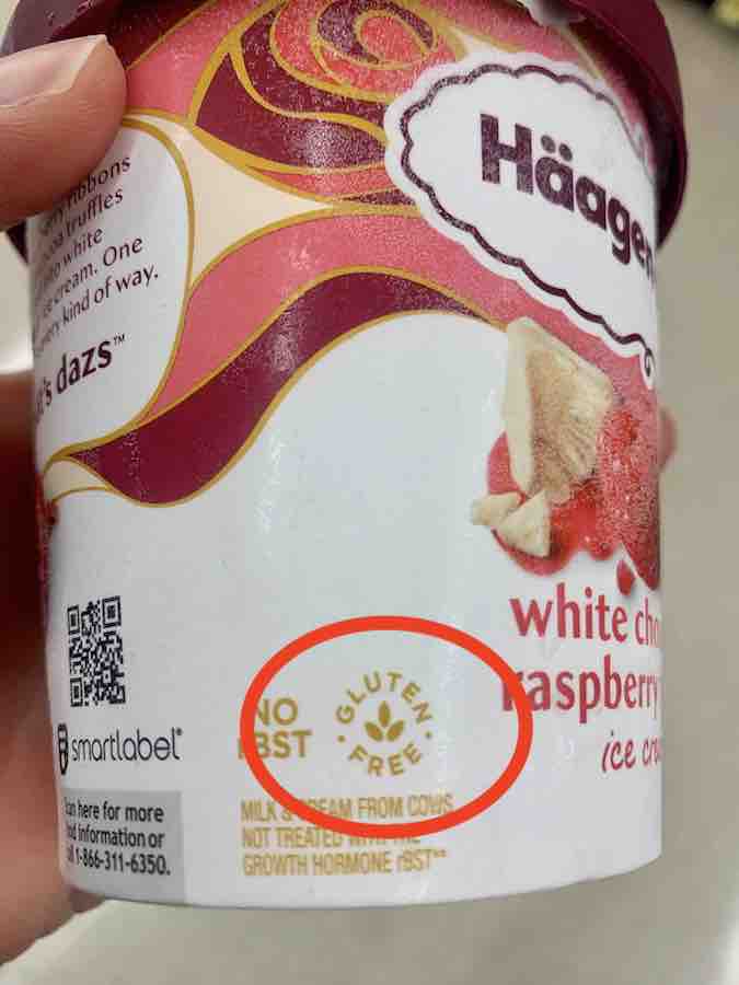 container of haagen-dazs white chocolate raspberry ice cream with gluten-free symbol (text gluten-free in a circle around a three leaf image, that appears like the very tip/top of wheat) circled in red