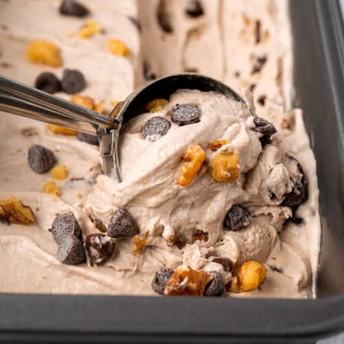 a scooper dipping into a tub of Vegan Chunky Monkey ice cream