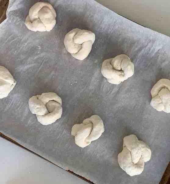 8 gluten-free garlic knots on a baking sheet, before rising