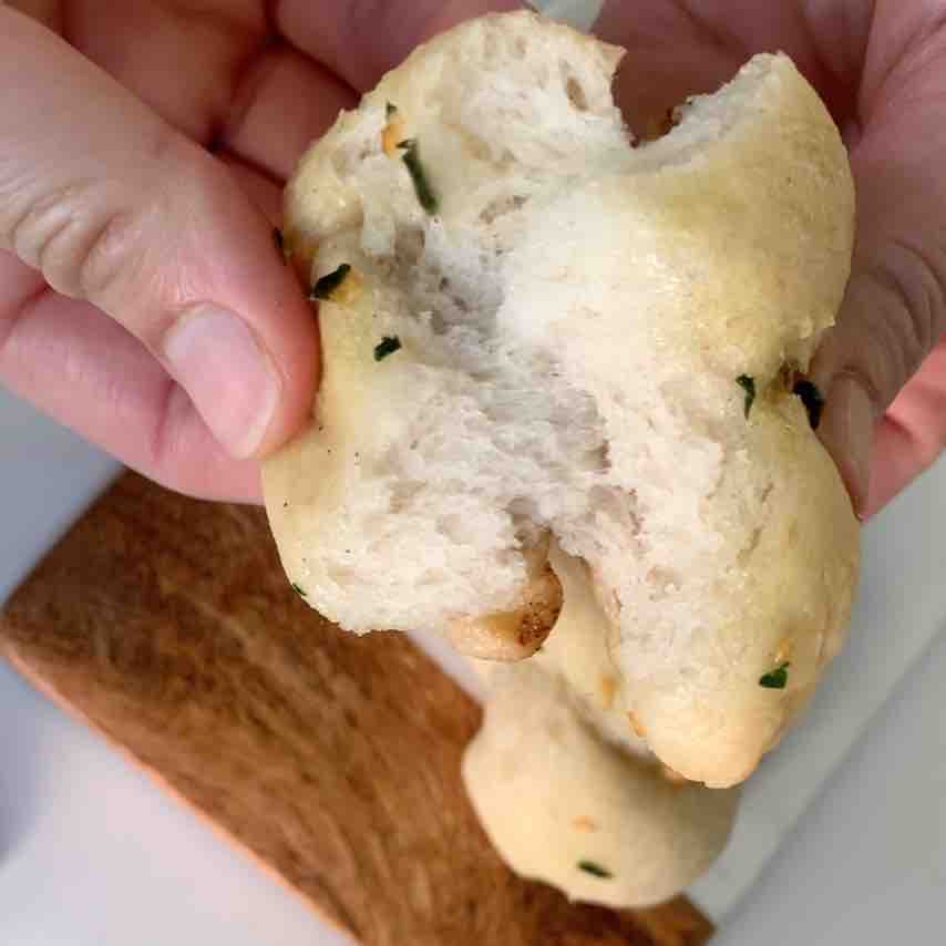 gluten-free garlic knot broken open showing real-bread, airy texture