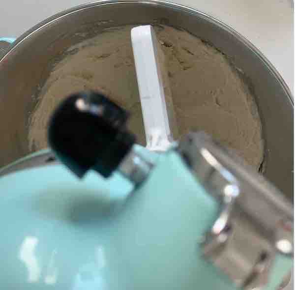 top view of an aqua-colored stand mixer mixing gluten free dough with a flat beater