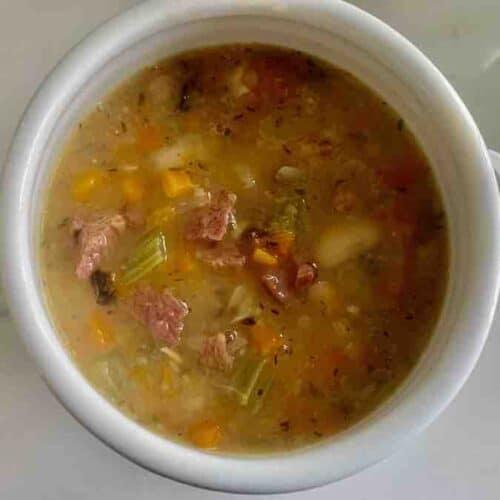 overhead view of Instant Pot ham and bean soup in a white bowl with handles