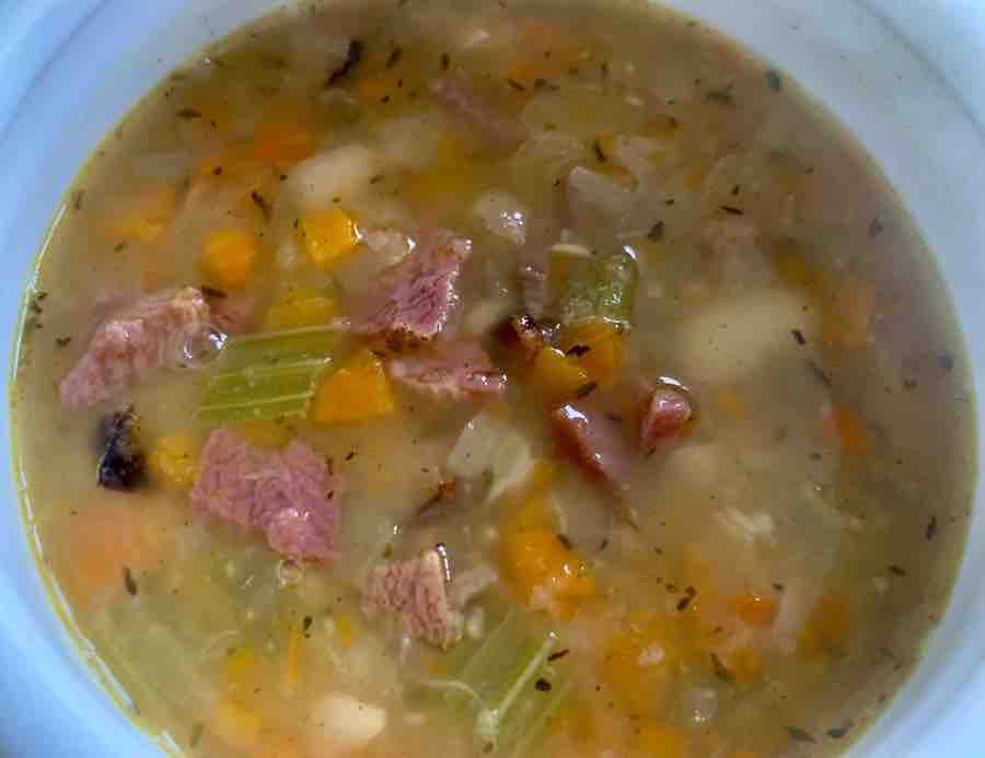 ham and bean soup in a white bowl (overhead view)