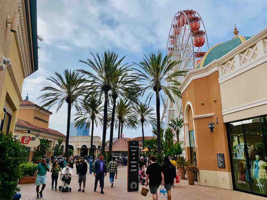 Irvine Spectrum Center shopping mall with shoppers, stores, palm trees and Ferris wheel