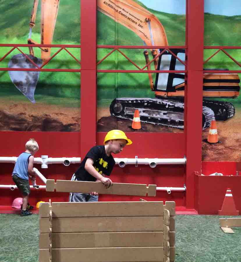 2 boys playing in the construction area of Pretend City