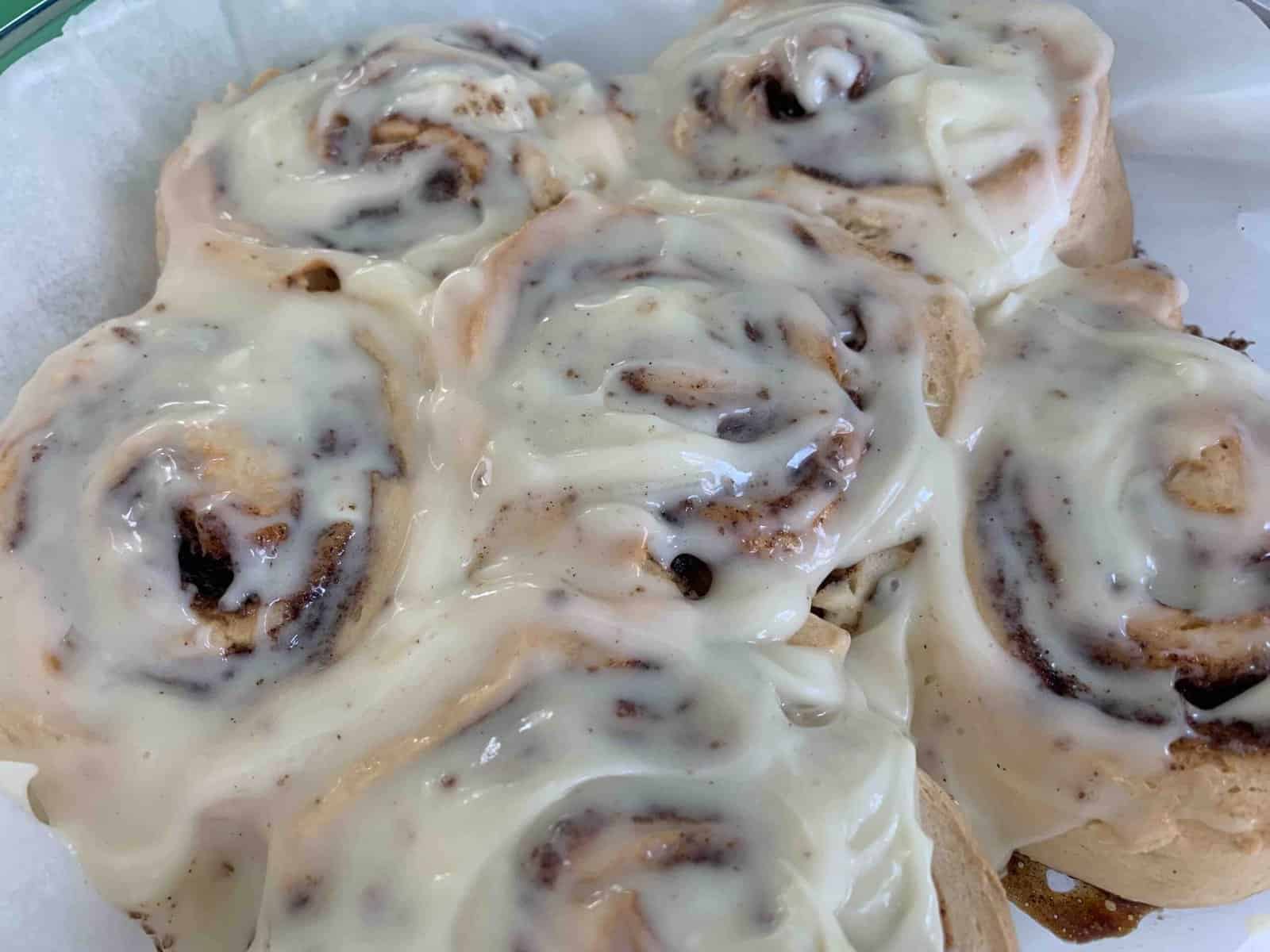a pan of 6 baked and frosted gluten-free cinnamon rolls