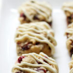 a row of three cranberry bliss bars with an icing drizzle, you can see just a bit of the next row of three bars on the right