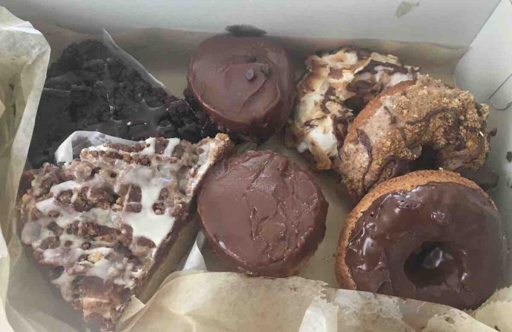 box of pastries, cinnamon coffee cake, chocolate cake, chocolate cupcakes and baked donuts
