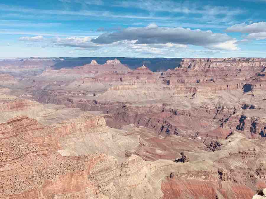 view of the Grand Canyon with blue sky and a few puffy clouds