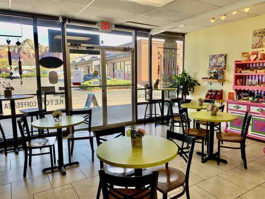 inside Karen's Bakehouse (gluten-free bakery) with tables, chairs, a handful of guests, and floor to ceiling windows showing off red rock views