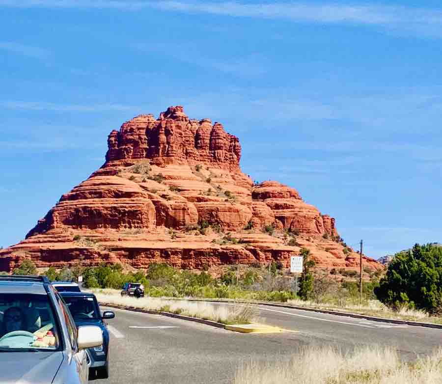"Bell Rock" (a butte) viewed from the highway, with the road and cars in the background