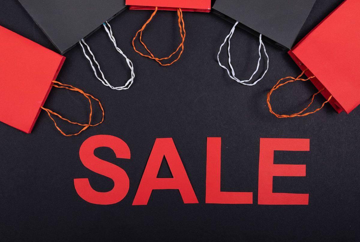 red text: sale, black background, empty black and red shopping bags with handles along the top