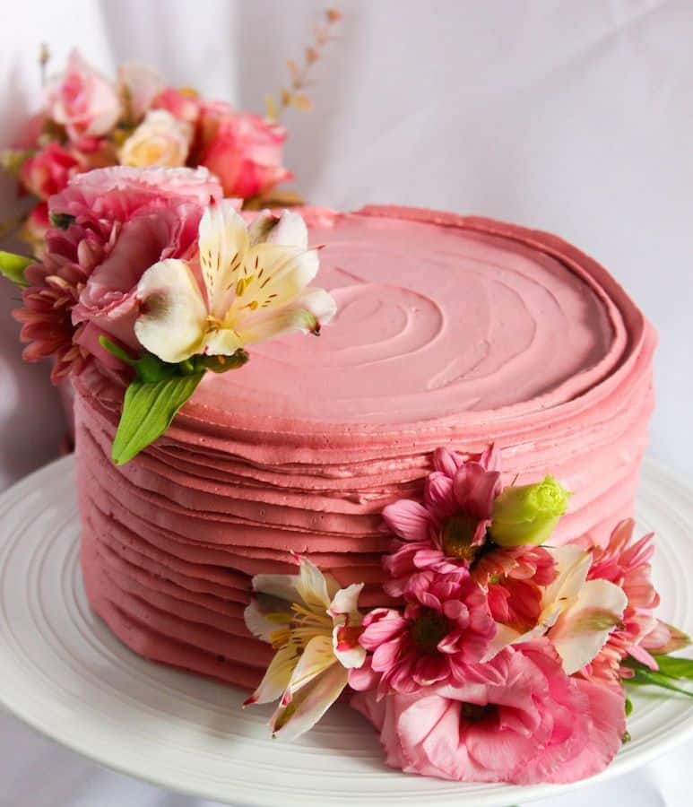 simple, raspberry colored cake decorated with flowers