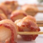 bacon wrapped scallops with side view of front piece clearly showing the scallop