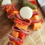 meat and cheese skewers, topped with cornichon pickles