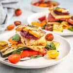 roasted vegetables, cheese and tomatoes on a plate, drizzled with balsamic