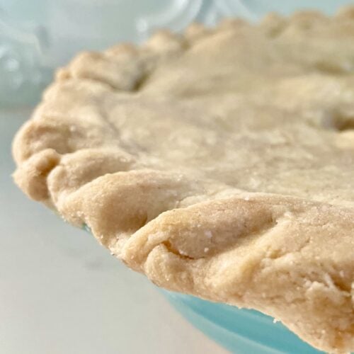 close up, partial, side of a gluten-free pie crust in a teal pie pan