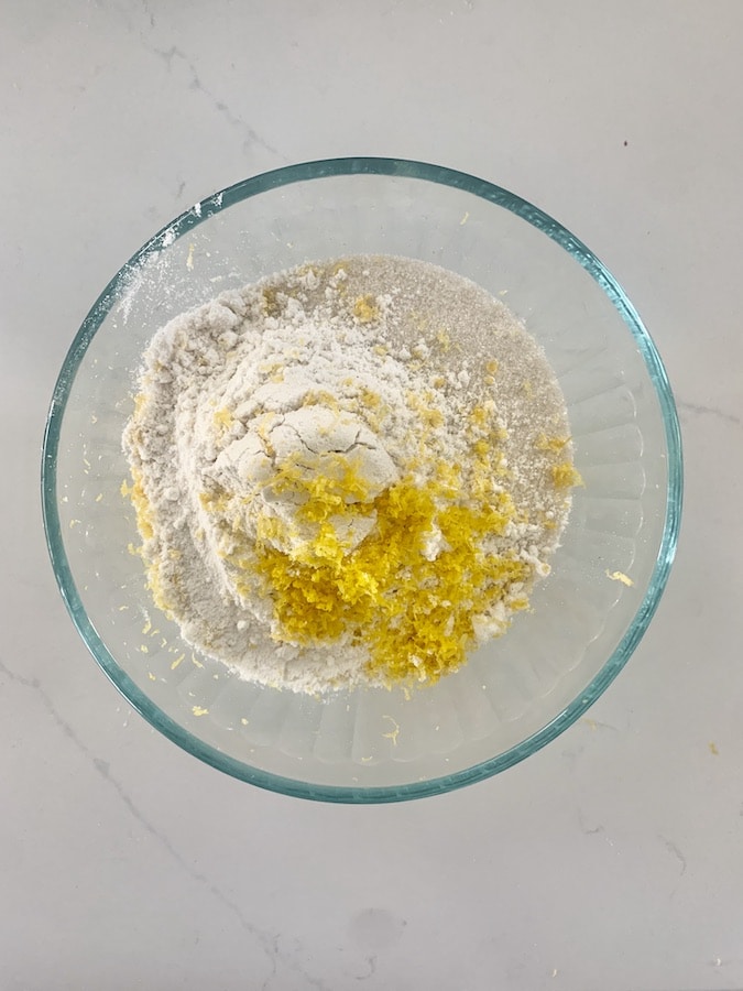 glass bowl with flour, sugar, and grated orange zest