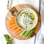 celery and carrots on a cutting board next to a bowl of whipped ricotta dip