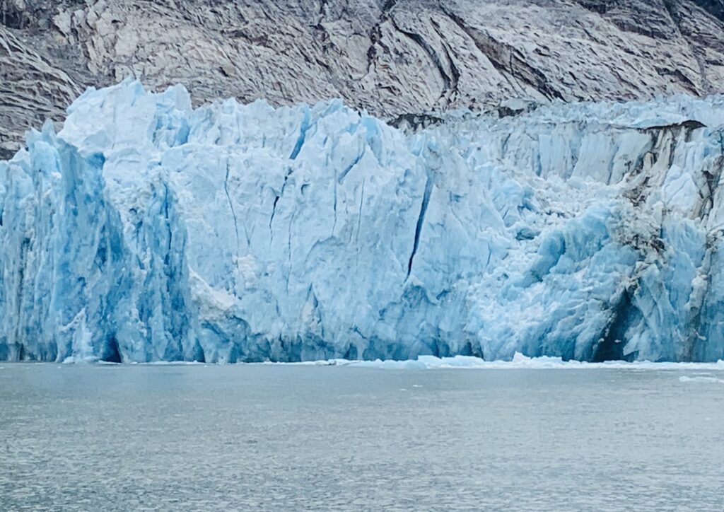 tall wall of Dawes Glacier which is blue as it meets the water
