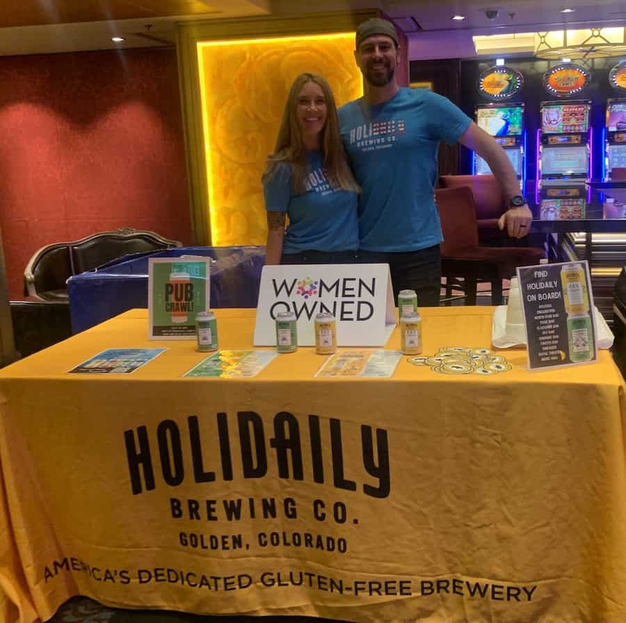 man and woman smiling behind Holiday gluten-free beer display table