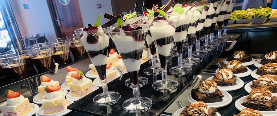 gluten-free dessert display: chocolate miss, vanilla cake with strawberries, berry parfait, chocolate brownie with caramel sauce
