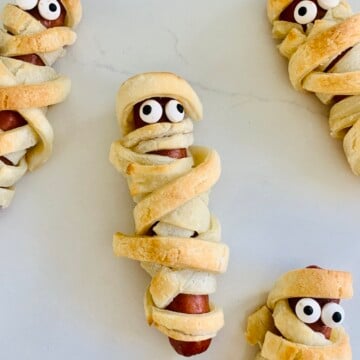 a gluten-free mummy hot dog wrapped in gluten-free puff pastry with candy eyes
