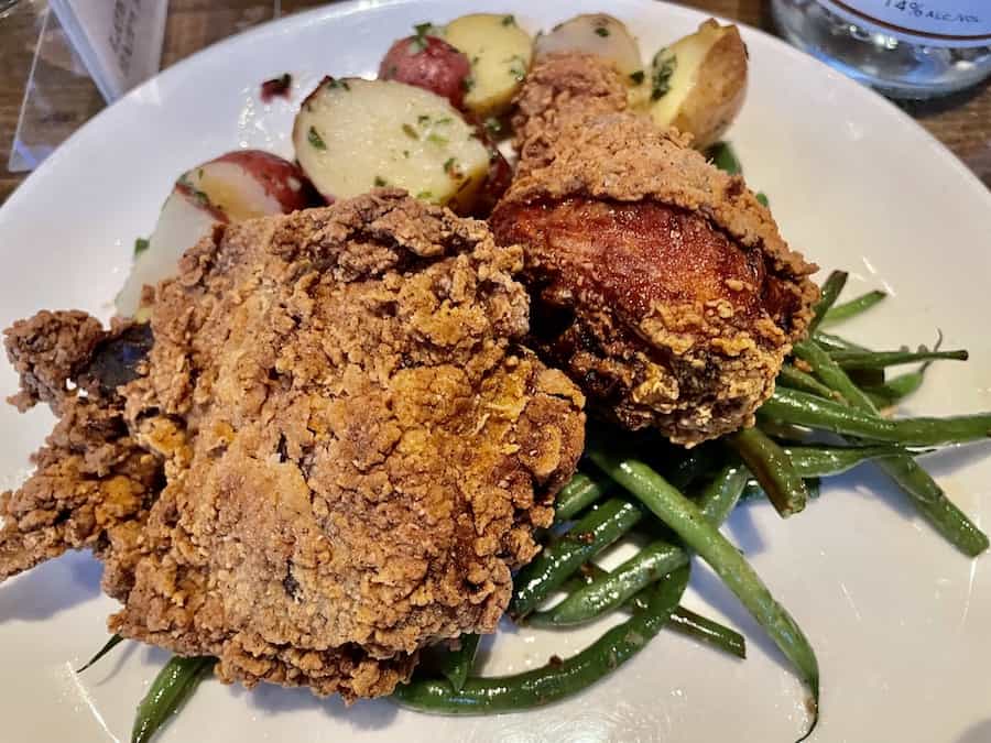 gluten-free fried chicken on top of green beans and potatoes