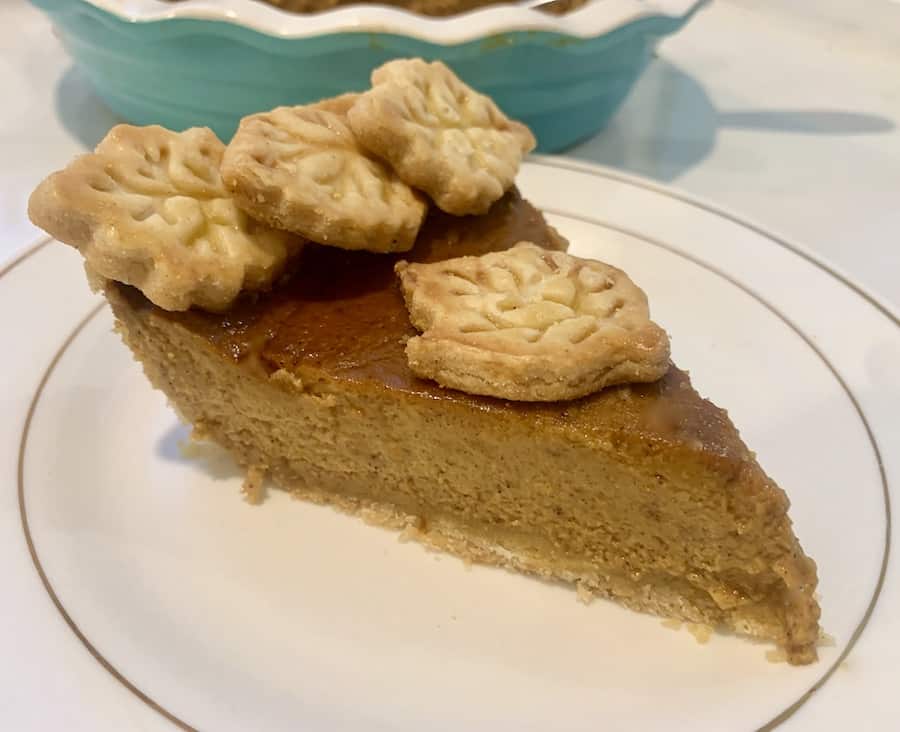 slice of pumpkin pie with pastry leaf cut-outs decorating the top