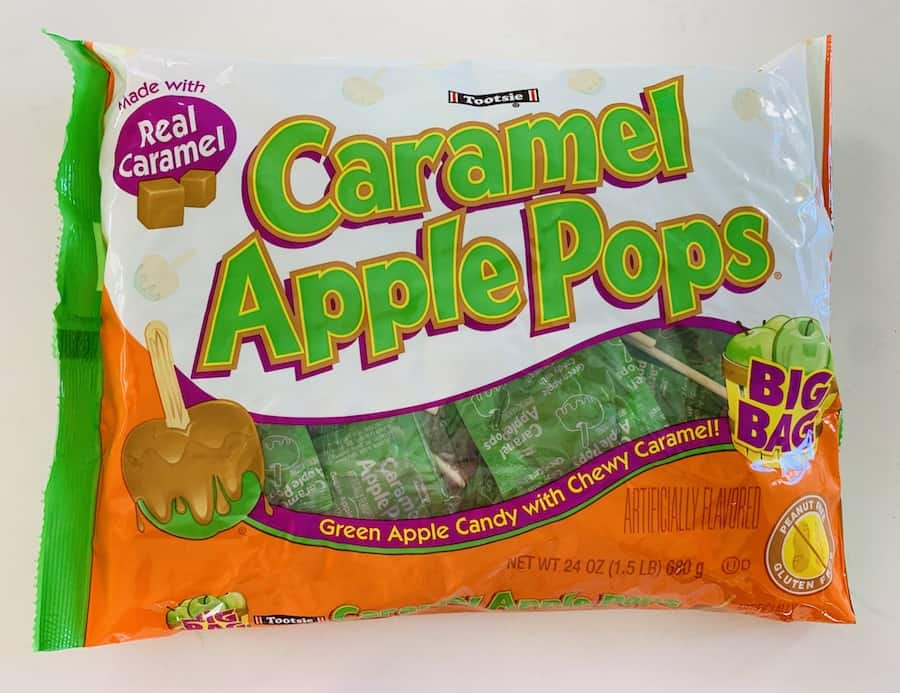 White and orange bag of lollipops with green text: "Caramel Apple Pops".