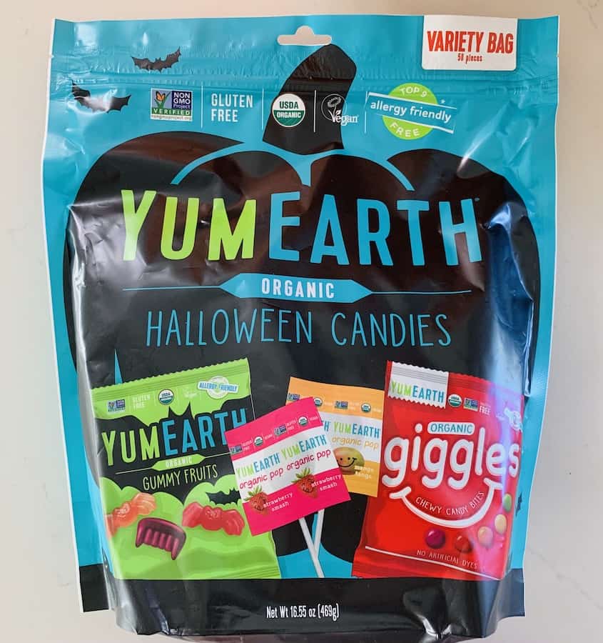Yum Earth Halloween Variety Pack containing: Yum Earth Gummy Fruits in Halloween Shapes like bats, lollipops, and Giggles (which look like Skittles candy).
