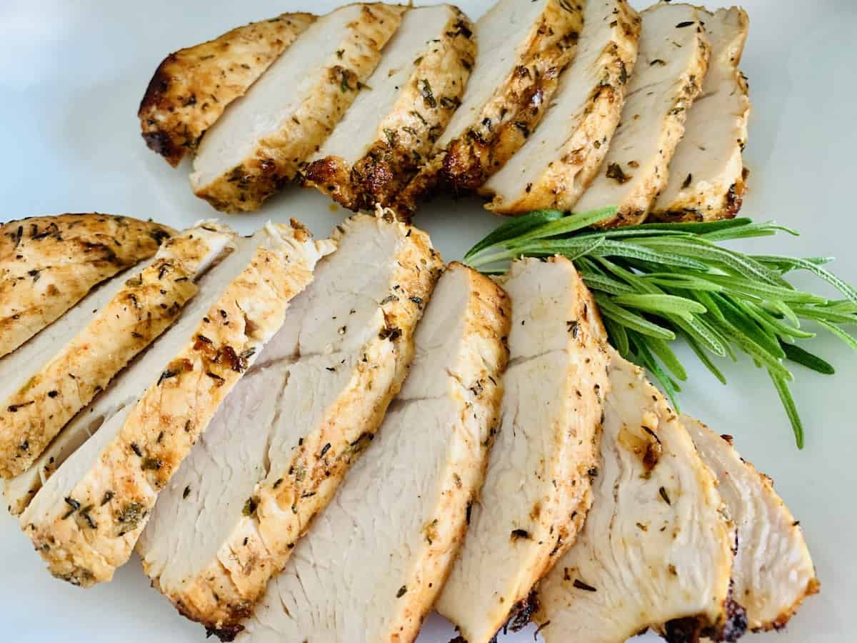 Slices of turkey laid out in two rows with a sprig of rosemary between the rows.
