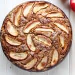 Birds' eye view of round apple ricotta cake, brown, with apple slices swirled along the top.