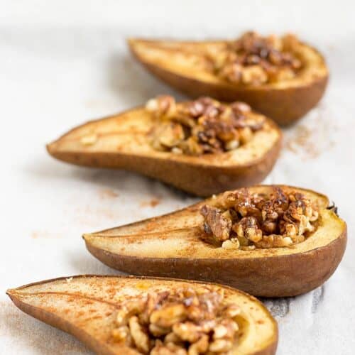 Four pear halves sprinkled with cinnamon and filled with walnut pieces.