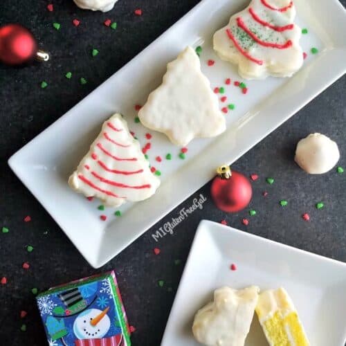Little Debbie-style mini Christmas tree-shaped cakes with white frosting and red and green decorations.