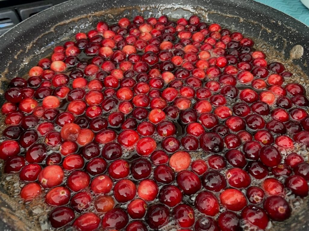 Frying pan cooking cranberries.