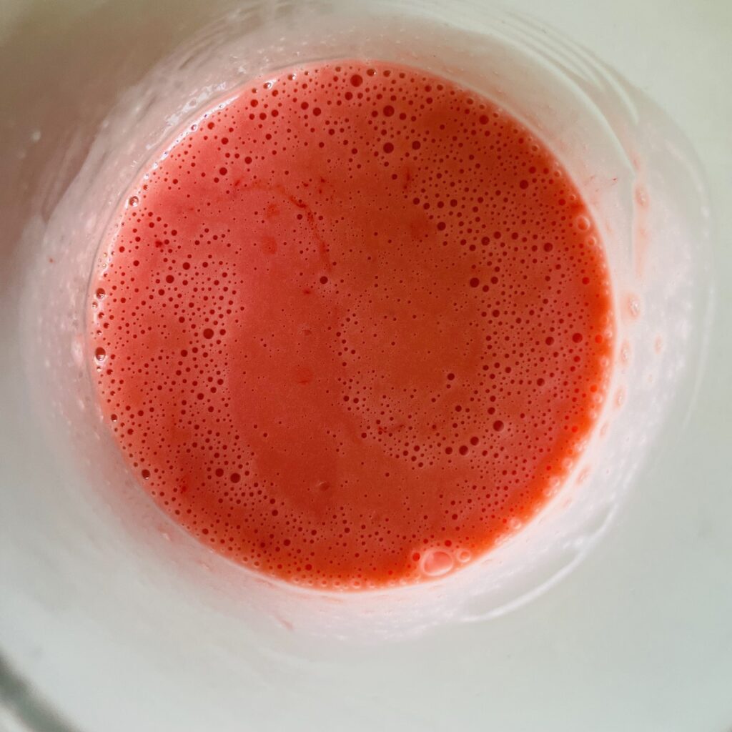 Birds eye view: bright pink/red batter in a cup.