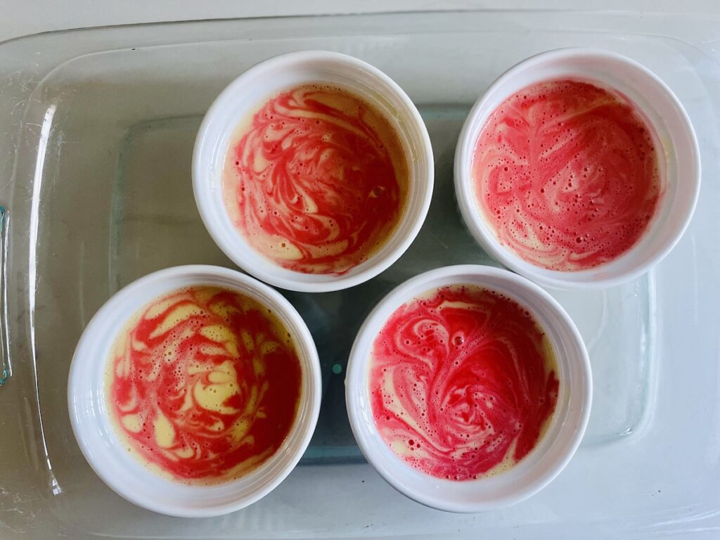 Birds eye view: unbaked creme brûlée with visible red and cream swirls