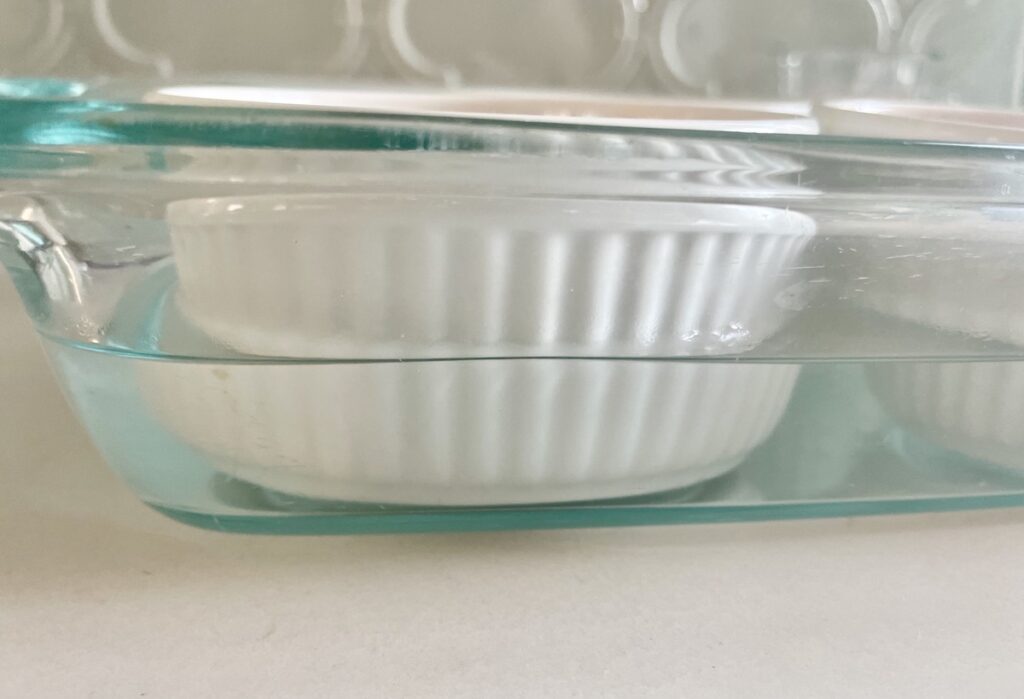 White ramekin in a glass baking dish filled halfway with water.