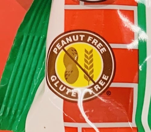 A peanut-free, gluten-free symbol with a crossed out pic of a peanut and wheat on a bag of candy.