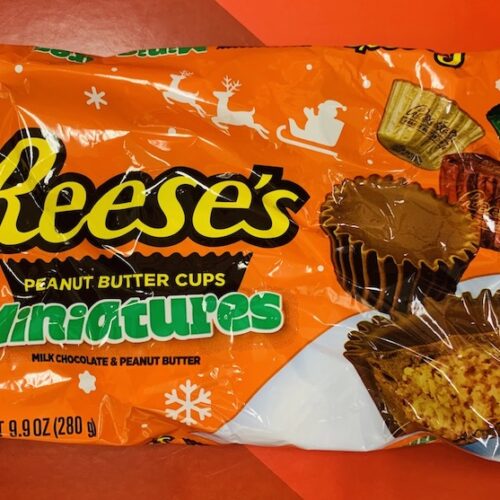 A bag of gluten-free Reese's Peanut Butter Cup Holiday Miniatures in red, green, and gold foils.