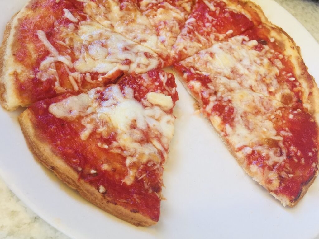 Gluten-free cheese pizza with missing slice.