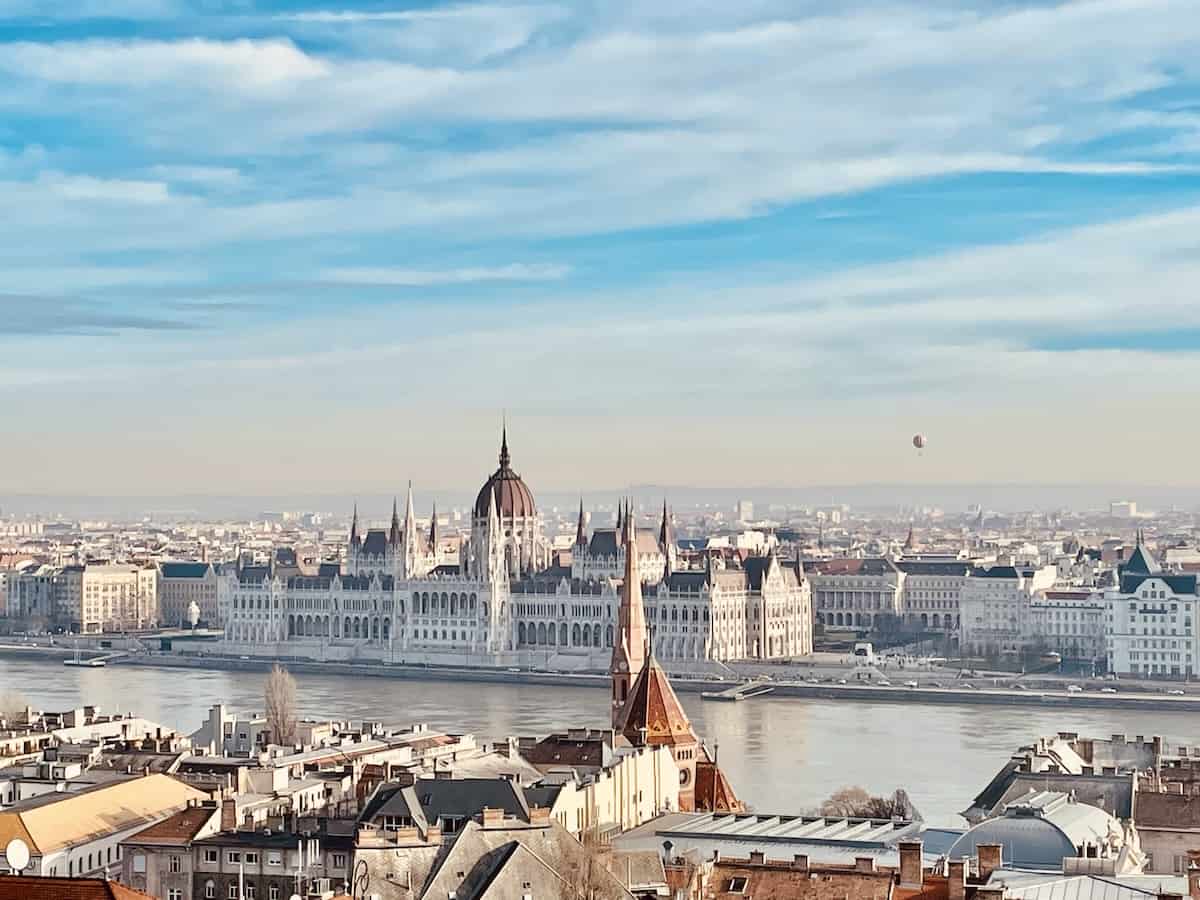 Cityscape of Budapest showing both sides of the Danube, with the domed roof of the Parliament building visible across the river.