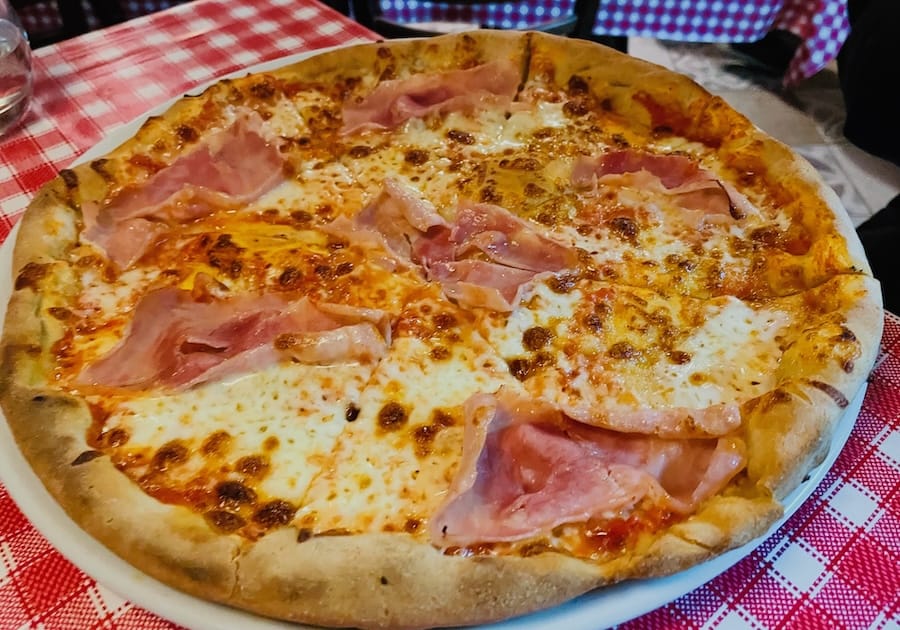 Gluten-free ham pizza with thick Neapolitan style crust.