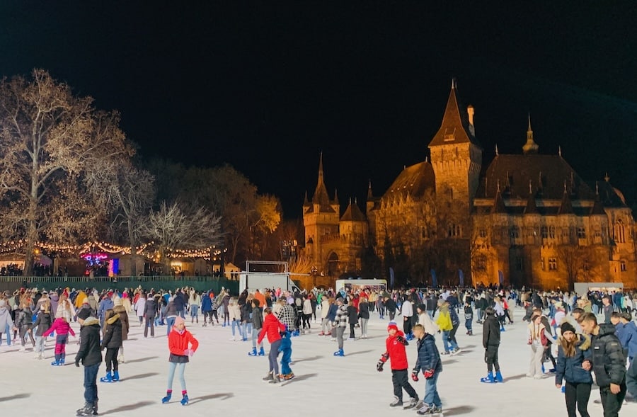 Outdoor ice skating with a castle and Christmas market in the background