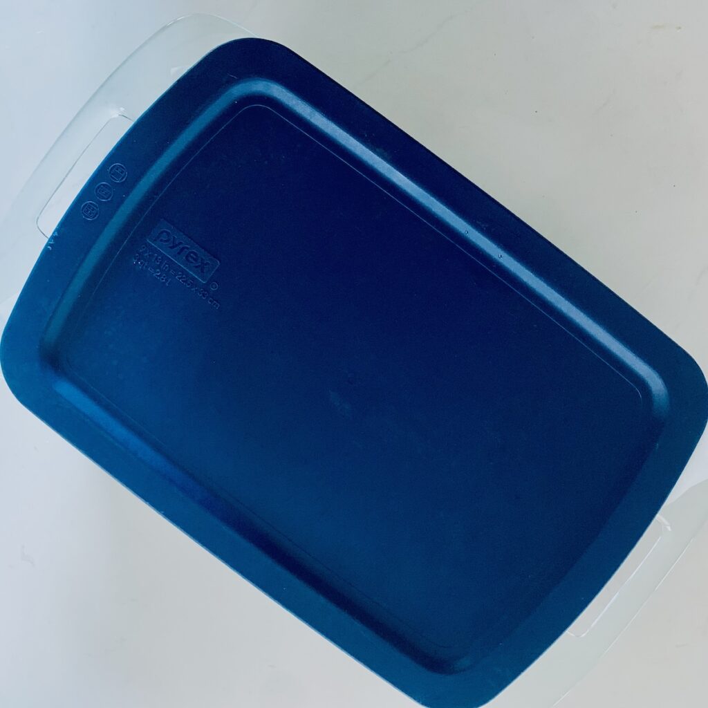 Birds Eye view: a blue lid on top of a rectangle pyrex baking dish.