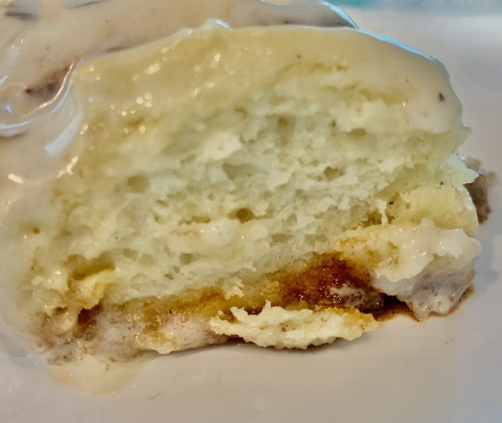 Side view of a fluffy, soft, gluten-free eggnog cinnamon roll.