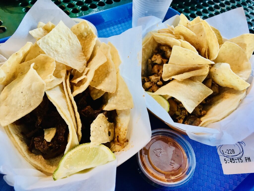 2 plates of tacos and tortilla chips.