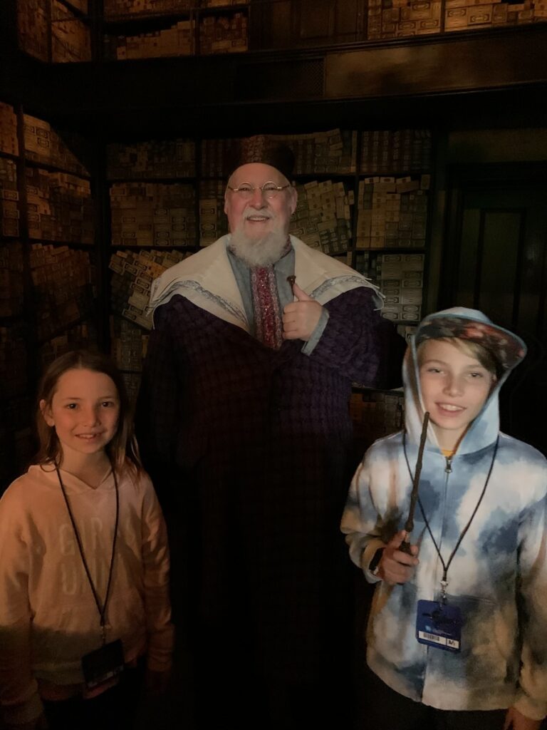 CJ & Miss E with robed wand keeper at Ollivander's